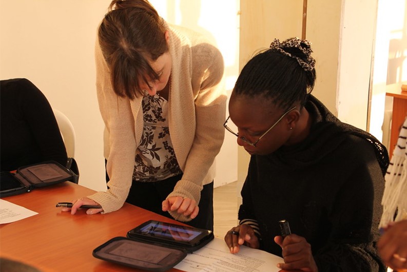A RTI employee shows an enumerator how to use an electronic version of the Early Grade Mathematics Assessment (EGMA) on the Kindle. Nairobi, Kenya.